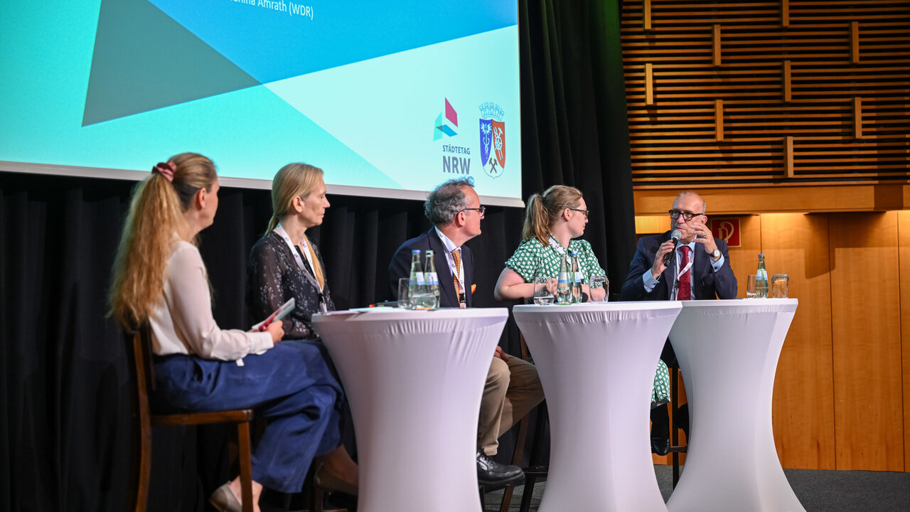 Forum A "Wer soll das bezahlen? Wer hat das bestellt? – Stadtfinanzen vor dem Kollaps?" mit (v.l.) Janina Amrath, Moderatorin, freie Journalistin beim WDR; Dr. Tanja Burckardt, Abteilungsleiterin V im Bundesministerium der Finanzen; Dr. Christian von Kraack, Abteilungsleiter Kommunales im Ministerium für Heimat, Kommunales, Bau und Digitalisierung des Landes NRW; Karoline Otte, MdB, Fraktion Bündnis 90/Die Grünen; Apostolos Tsalastras, Stadtkämmerer Stadt Oberhausen