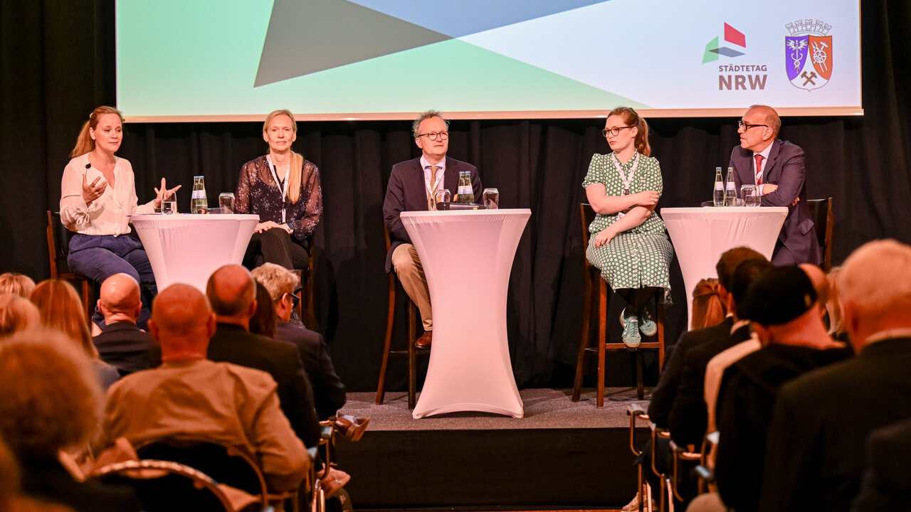 Forum A "Wer soll das bezahlen? Wer hat das bestellt? – Stadtfinanzen vor dem Kollaps?" mit (v.l.) Janina Amrath, Moderatorin, freie Journalistin beim WDR; Dr. Tanja Burckardt, Abteilungsleiterin V im Bundesministerium der Finanzen; Dr. Christian von Kraack, Abteilungsleiter Kommunales im Ministerium für Heimat, Kommunales, Bau und Digitalisierung des Landes NRW; Karoline Otte, MdB, Fraktion Bündnis 90/Die Grünen; Apostolos Tsalastras, Stadtkämmerer Stadt Oberhausen