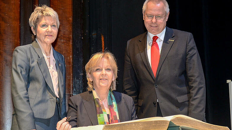 Ministerpräsidentin Hannelore Kraft trägt sich in das Goldene Buch der Stadt Mülheim an der Ruhr ein. Links Oberbürgermeisterin Dagmar Mühlenfeld, rechts der bisherige Vorsitzende des Städtetages NRW Norbert Bude