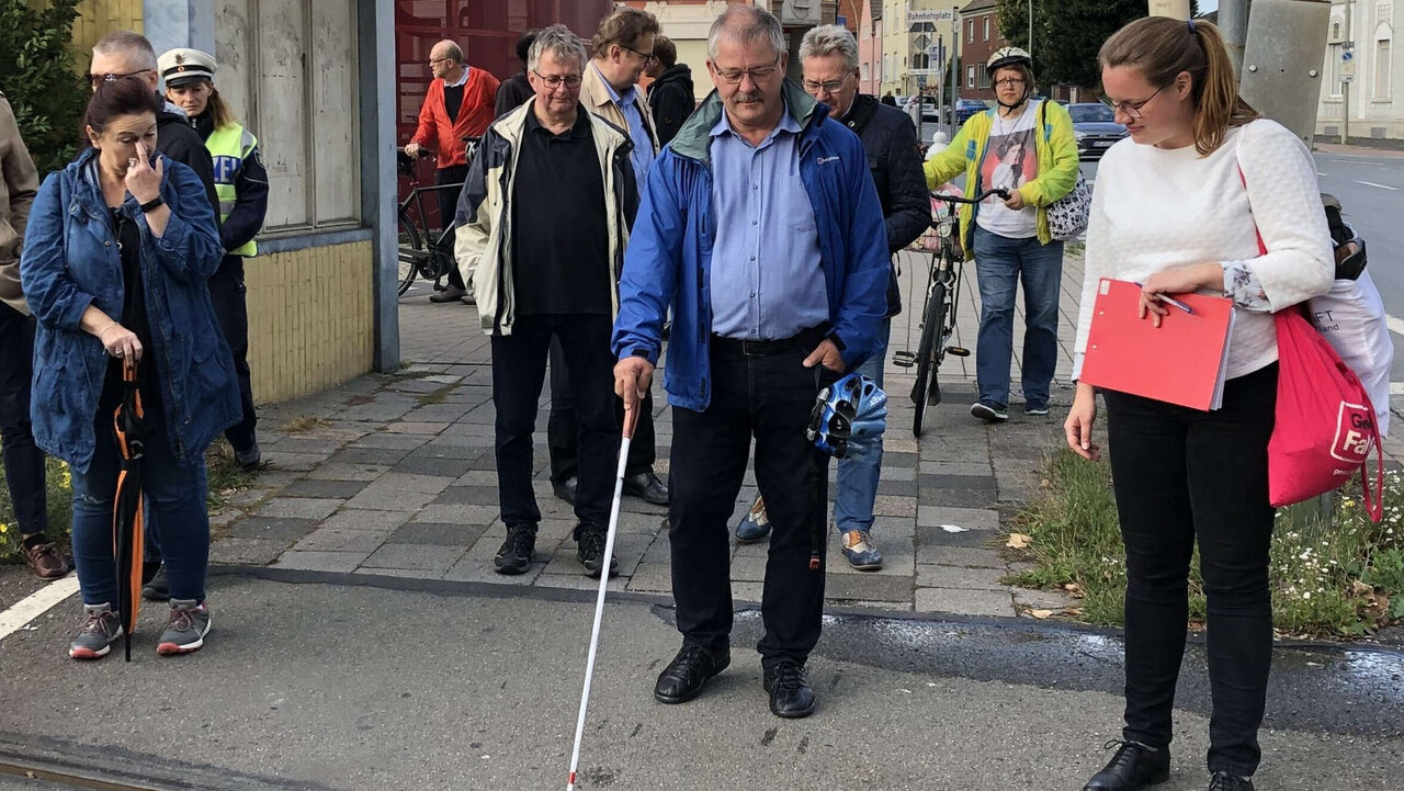 Mann tastet mit Blindenstück Gehweg in Beckum ab. 