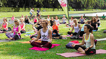Teilnehmende der Aktion "Sport in Park" machen Yoga in einem Düsseldorfer Park. 